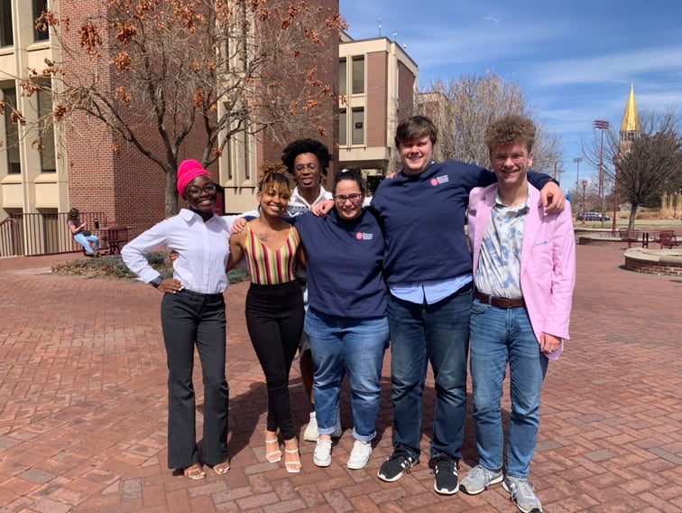 Student members of the Warren Debate Union posed in front of classroom buildings at the University of Denver